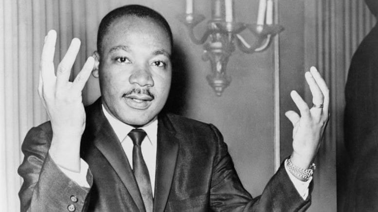 Martin Luther King, Jr. with his hands raised, palms inward