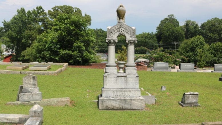 A cemetery marker in the shape of an elaborate arch.