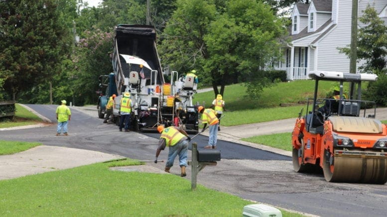 Repaving Brookside Drive -- trucks spread asphalt