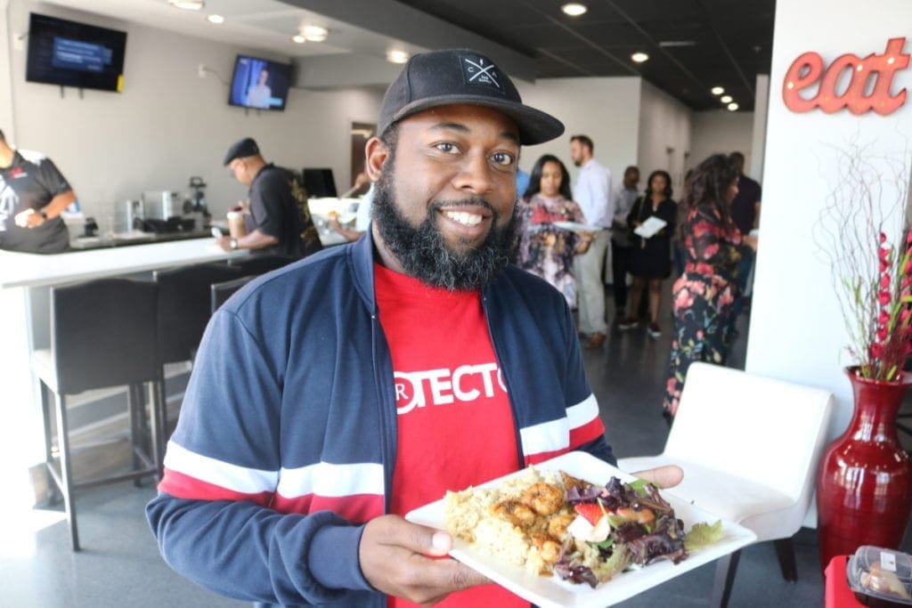 South Cobb Alliance organizer and Cafe Social House customer Tre'Hutchins with a plate of the restaurant's food (photo by Larry Felton Johnson)