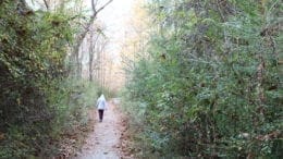 Hooded figure walking down trail in Heritage Park in Mabelton.