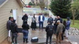 meeting about Riverside Parkway apartments. Circle of people standing by a swimming pool.