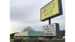 Brij Patel, director of marketing for Sprayberry Bottle Shop, has been vocal with his frustration over the condition of the adjacent Sprayberry Crossing property and the illegal dumping that takes place near his store. He put this sign up in conjunction with the planned social media campaign. (photo by Rebecca Gaunt)