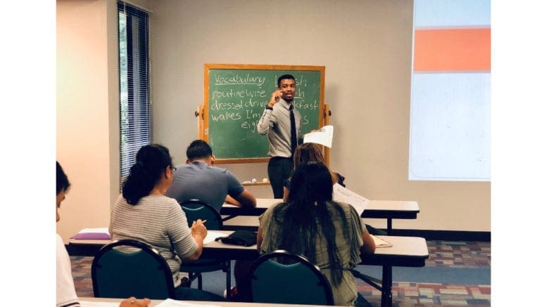 Steven Valentine, an English instructor with Family Kickstart Georgia, in front of his ESL classroom lecturing