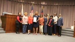 A group of officers from American Legion Auxiliary Paul E Kelly Unit in line displaying proclamation presented to them by Commissioner JoAnn Birrell