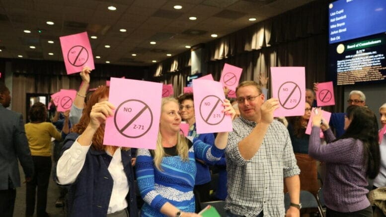 Neigbors holding signs at BOC meeting about Chastain Road development