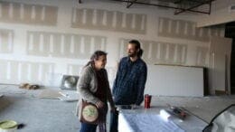 Linda and Ben Brackner in the Green Room, with ongoing work to the unfinished space in the background