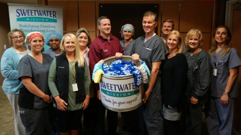 Group photo with sock donation box from Sweetwater Mission