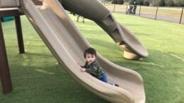 One-year-old Eric Barrera enjoyed sliding onto the new turf ground covering at Kennesaw inclusive playground.