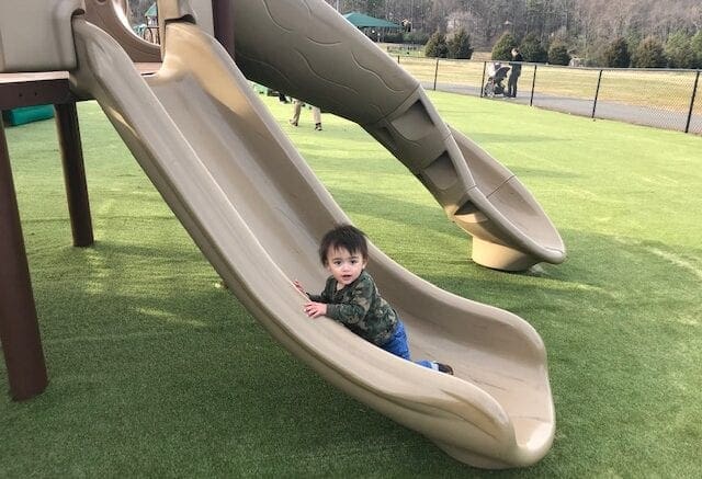 One-year-old Eric Barrera enjoyed sliding onto the new turf ground covering at Kennesaw inclusive playground.