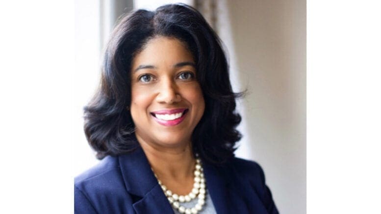 Jannquell Peters headshot smiling wearing a blue jacket