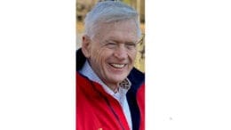 Larry Davage, smiling, in red jacket