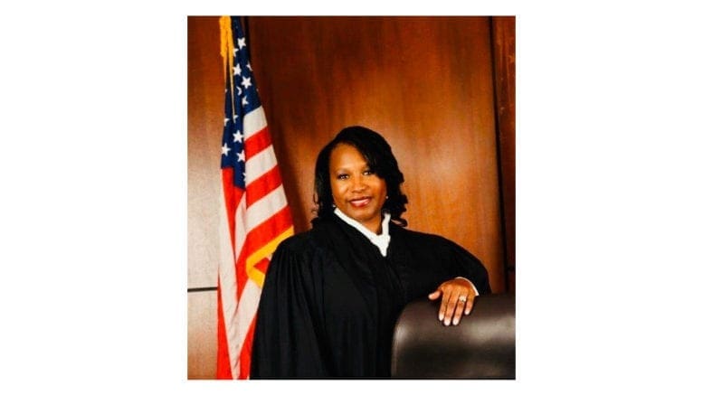 Judge Kellie Hill standing beside the bench