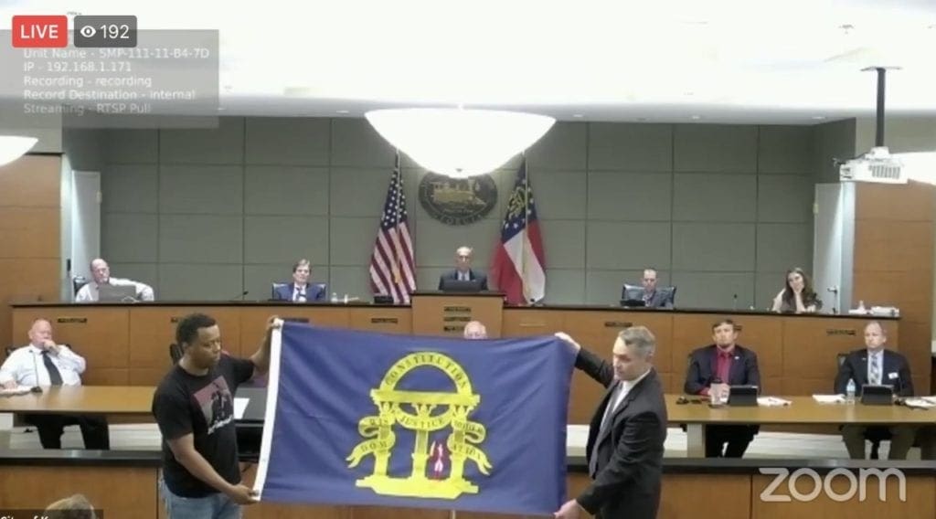 Former Councilman Jimmy Dickens and Rep. Ed Setzler display the historically-accurate replacement flag.