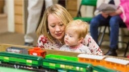 child looks over model railroad at museum