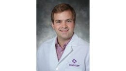 Dr. Jonathan Peeples, Wellstars Director of Telepsychiatry in lab coat with Wellstar logo