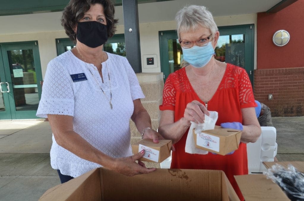 Wynn McCurdy, Cheryl Lenney preparing boxes from Aj's Seafood and Po Boys