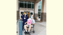 Nicholas Blehm discharged holding signed lung pillow at entrance to hospital