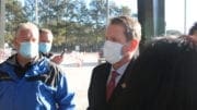 Governor Brian Kemp wearing a mask speaking to reporters