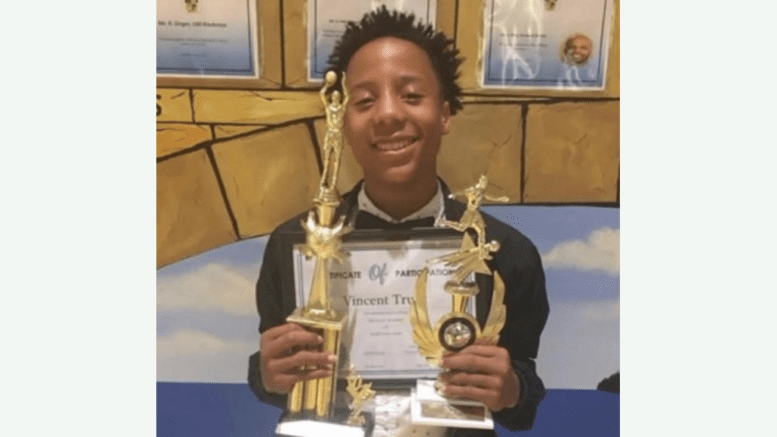 Vincent Truitt holding two trophies