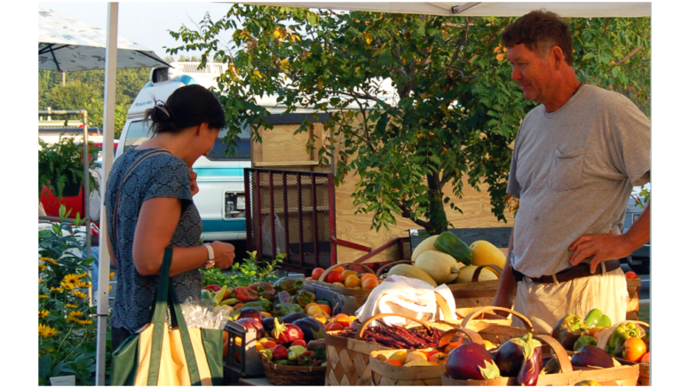 A man and woman looking over vegetables at the Kennesaw Farmers Market