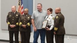 Sheriff Craig Owens, Chief Deputy Rhonda Anderson and Assistant Chief Deputy Michael Register promote Amie Garrett, with her husband looking on (photo by Arielle Robinson)