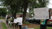 protestors against evictions hold signs in front of apartment complex