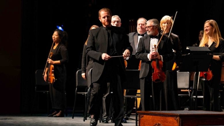 Music Director and Conductor Timothy Verville (pictured, standing center) leads the Georgia Symphony Orchestra’s return to live performances in its upcoming 71st concert season