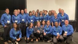 EMS Technology Solutions staff lined up in two rows, the front row kneeling the back standing.