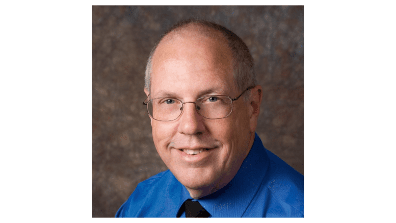 Tim Richardson in blue dress shirt with tie