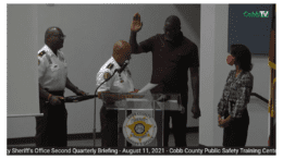 Dominique Wilkins, hand raised, as Sheriff Craig Owens swears him in