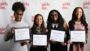 Four girls holding award certificates