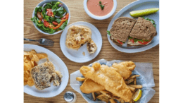 An assortment of meat pies an fish and chips spread out on a table