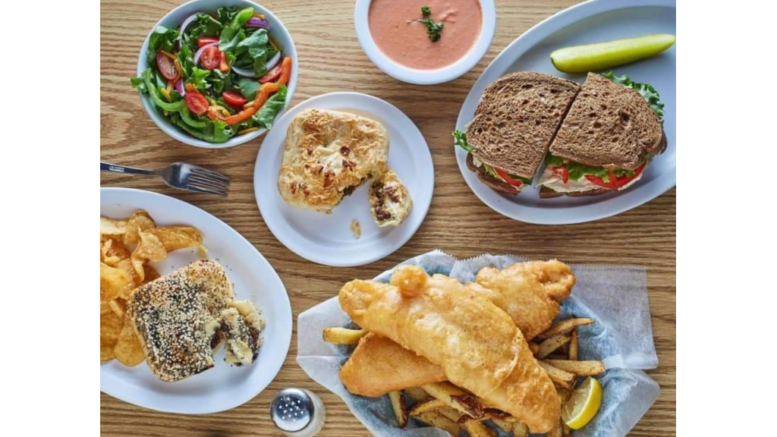 An assortment of meat pies an fish and chips spread out on a table