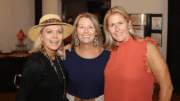 Three women in museum smiling toward the camera