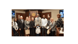 Group photo of three fathers and court staff celebrating graduation from Parental Accountability Court