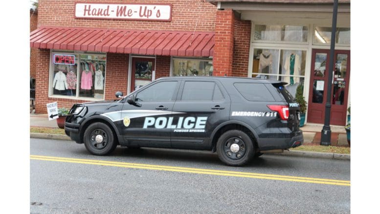 Powder Springs police SUV in front of brick clothing store