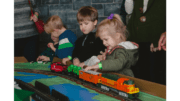 Children playing with a model train set on a platform