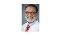 headshot photo of Dr. Arif Aziz wearing lab jacket with tie