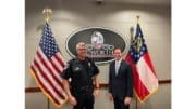 Wayne Dennard and Jesse Evans standing between a U.S. flag and a Georgia flag