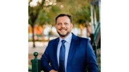 headshot photo of Dustin McCormick in suit with trees in the background