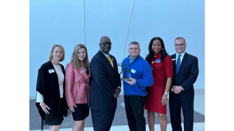 Standing left to right dressed in business attire: 2022 Cobb Chamber Chairwoman Britt Fleck, Cobb Chamber CEO Sharon Mason, Powder Springs Mayor Al Thurman, 2021 Powder Springs Citizen of the Year Kelly Fisk, South Cobb Area Council Director Delphine LaGroon, and South Cobb Area Council Director Smith Peck.