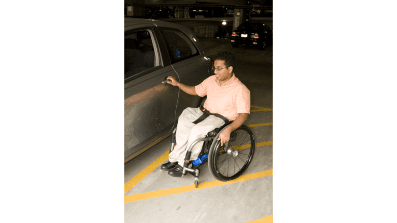 Man in a wheelchair opening a car door