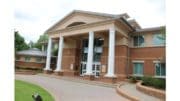 The exterior of Smyrna City Hall, a red brick building with four large columns