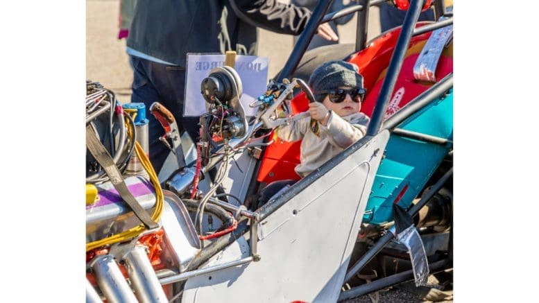 little boy seated in a race car