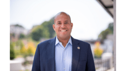 Jason Esteves outdoors, smiling, wearing suit jacket