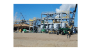 A geothermal plant -- metal frames, five tank, billowing steam