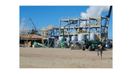 A geothermal plant -- metal frames, five tank, billowing steam