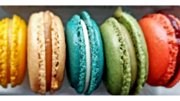 a row of brightly colored cookie-shaped pastries lined up on their ends