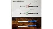 Two test strips, one showing positive for fentanyl, the other negative